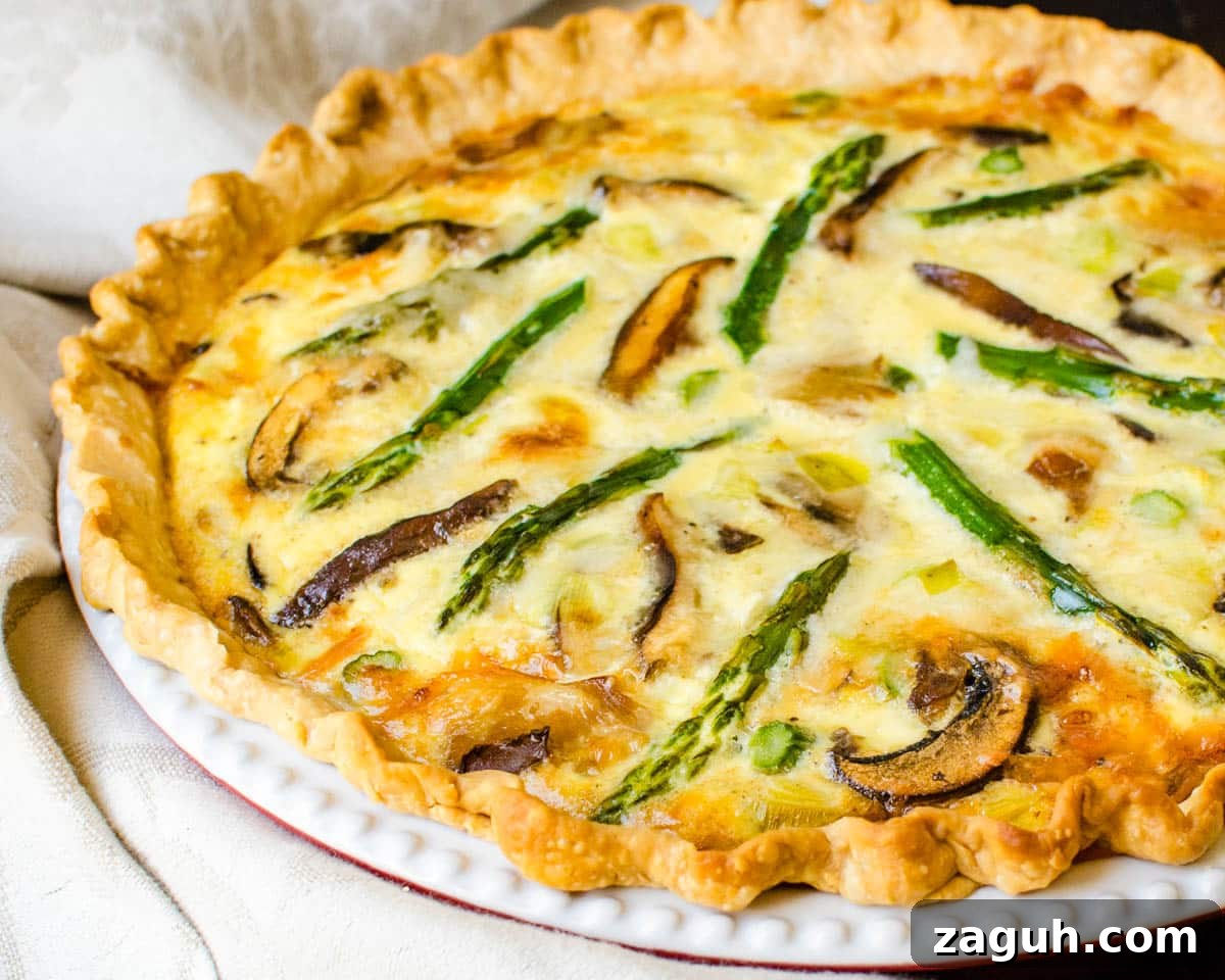 Asparagus, Mushroom & Gruyère Quiche with Leeks for Spring Brunch 6 Asparagus quiche baked in a ceramic pie plate.