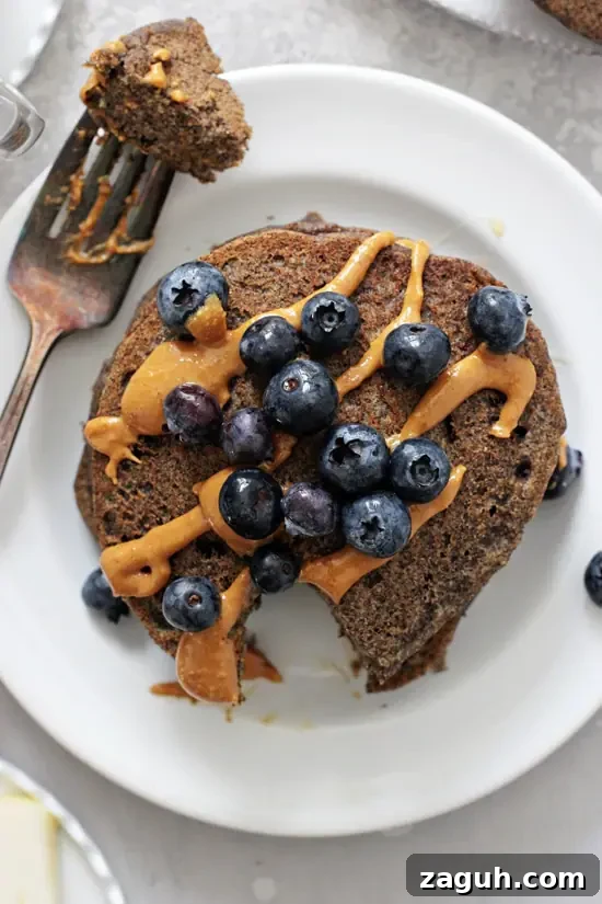 Whip up a batch of these fluffy vegan buckwheat pancakes for a delicious healthy breakfast! Easy, tender and filled with a touch of warm cinnamon, these from scratch gluten free pancakes are hard to beat! Fluffy Buckwheat Pancakes on a plate with a bite taken out with a fork.