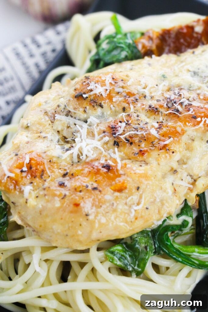 Tuscan-Style Creamy Garlic Chicken with Sun-Dried Tomatoes 3 Tuscan chicken on top of a bed of pasta on a plate sitting on a table