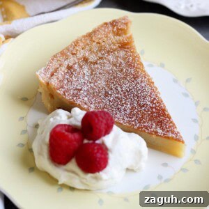 Classic Homemade Custard Pie Recipe for Rich, Creamy Filling 10 A slice of custard pie on a plate with whipped cream and raspberries.