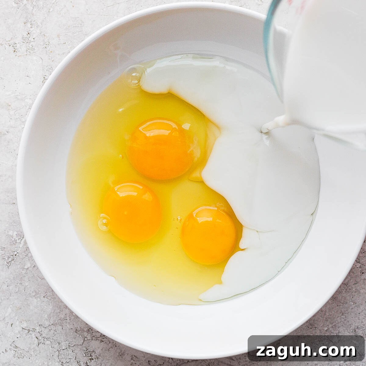 15-Minute Cinnamon French Toast Recipe for Busy Mornings 6 Pouring milk in a bowl with three eggs.