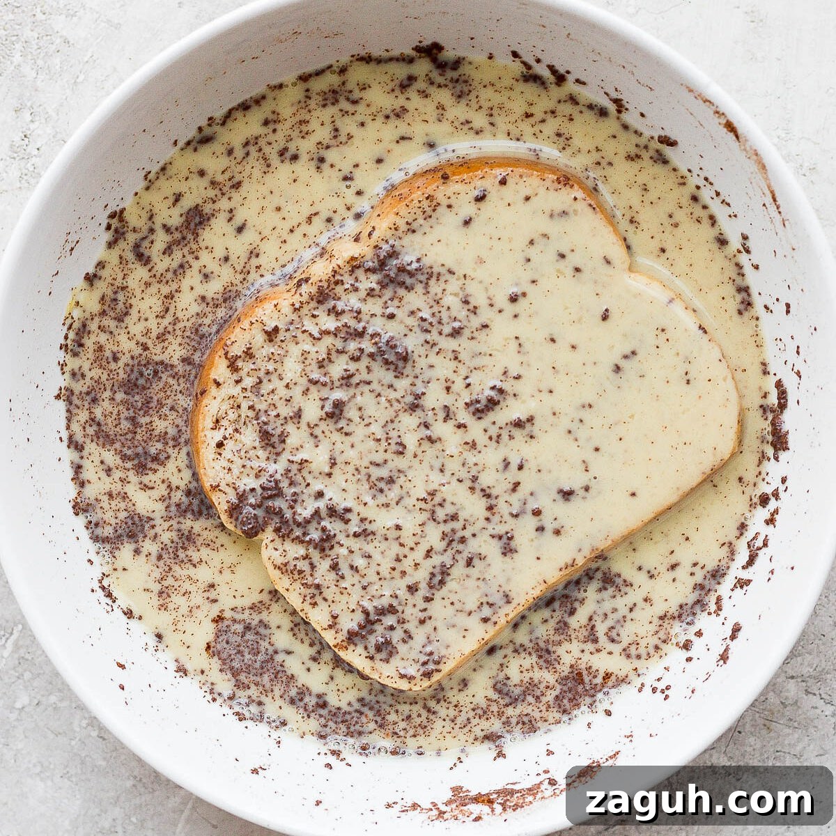 15-Minute Cinnamon French Toast Recipe for Busy Mornings 7 Soaking slice of bread in custard mixture.