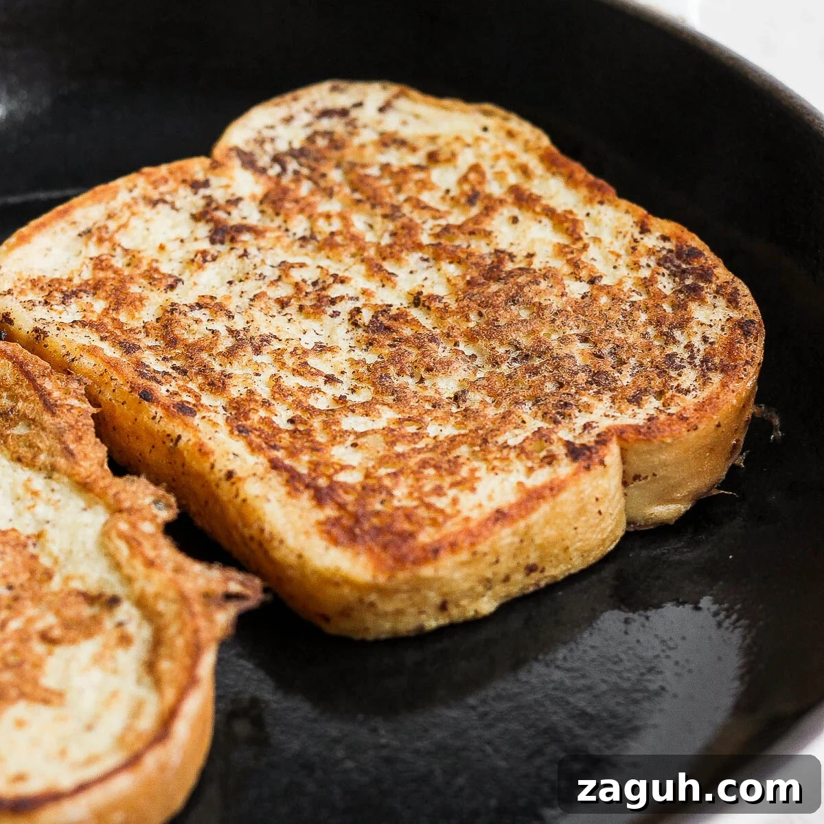 15-Minute Cinnamon French Toast Recipe for Busy Mornings 8 Slice of French toast cooking in a pan.