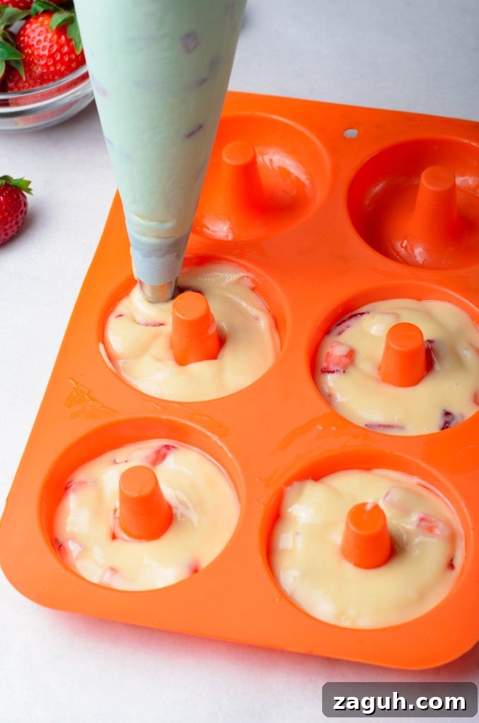 Strawberry-Glazed Baked Donuts: Light, Fruity Recipe 5 strawberry donut batter shown being piped into a silicone donut mold