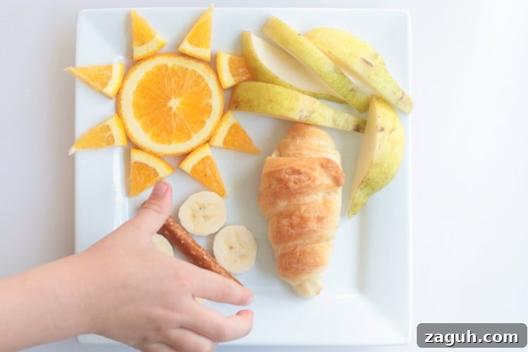 Butterfly Life Cycle Lunch Activity for Preschoolers (Video) 3 hand picking up pretzel from butterfly lunch