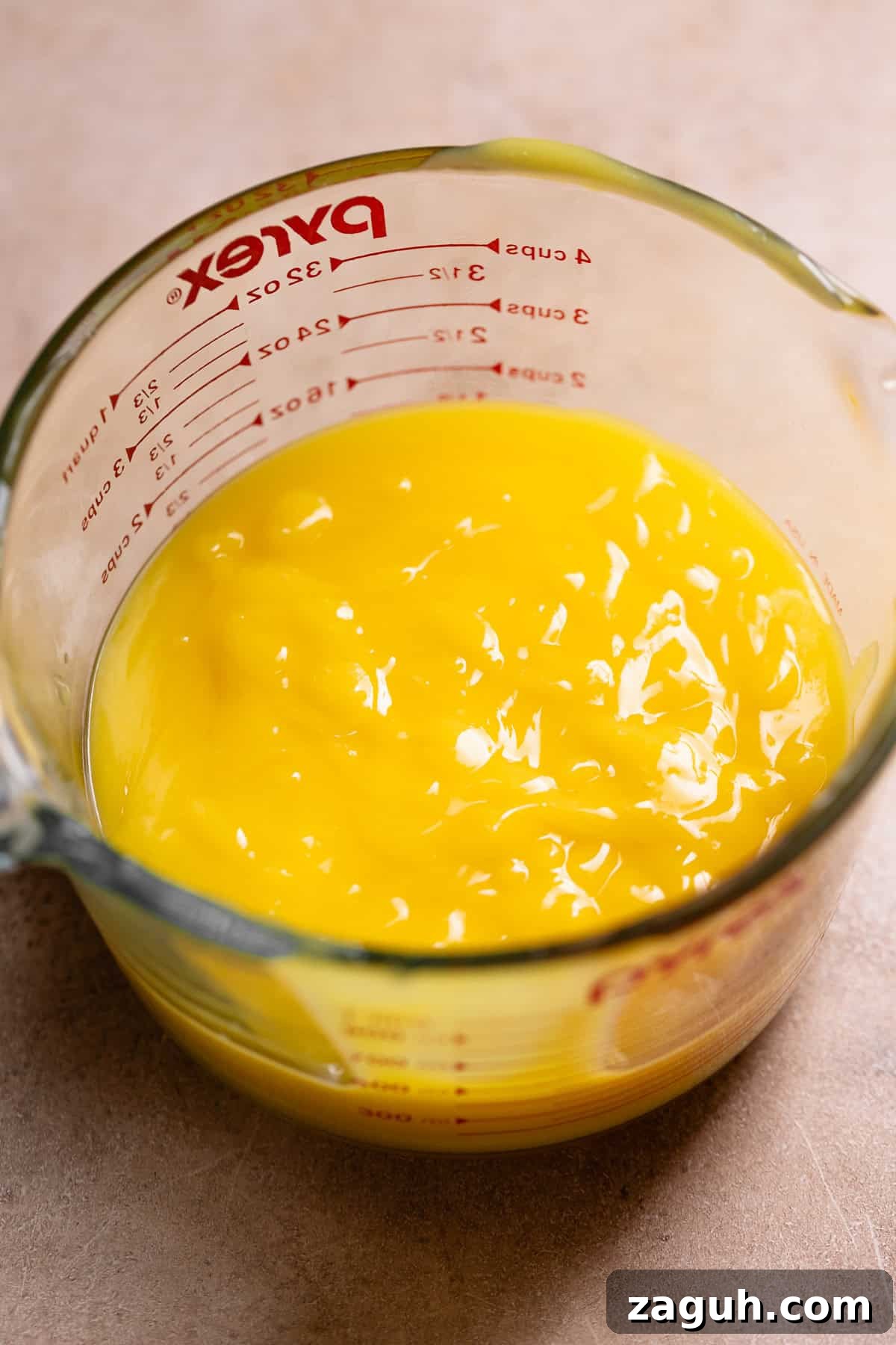Tangy Lemon Bars with Buttery Shortbread Crust 6 Lemon curd in a glass measuring cup.