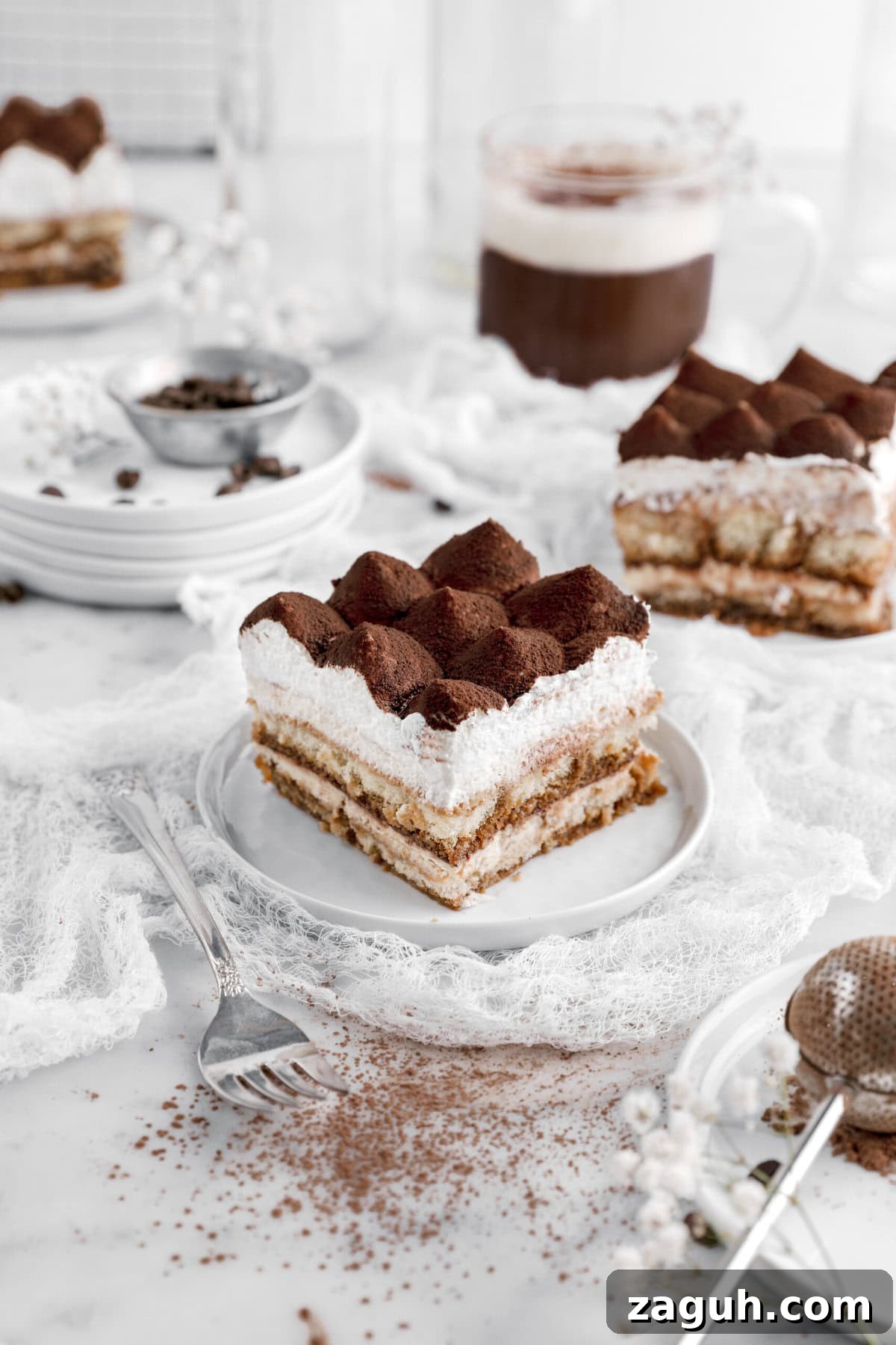 Authentic Italian Tiramisu Recipe: Step-by-Step Classic Guide 12 angled image of tiramisu on white plate with two more slices behind.