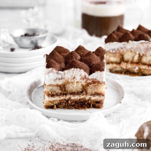 Authentic Italian Tiramisu Recipe: Step-by-Step Classic Guide 18 slice of tiramisu on white plate with second slice behind and mug of coffee.