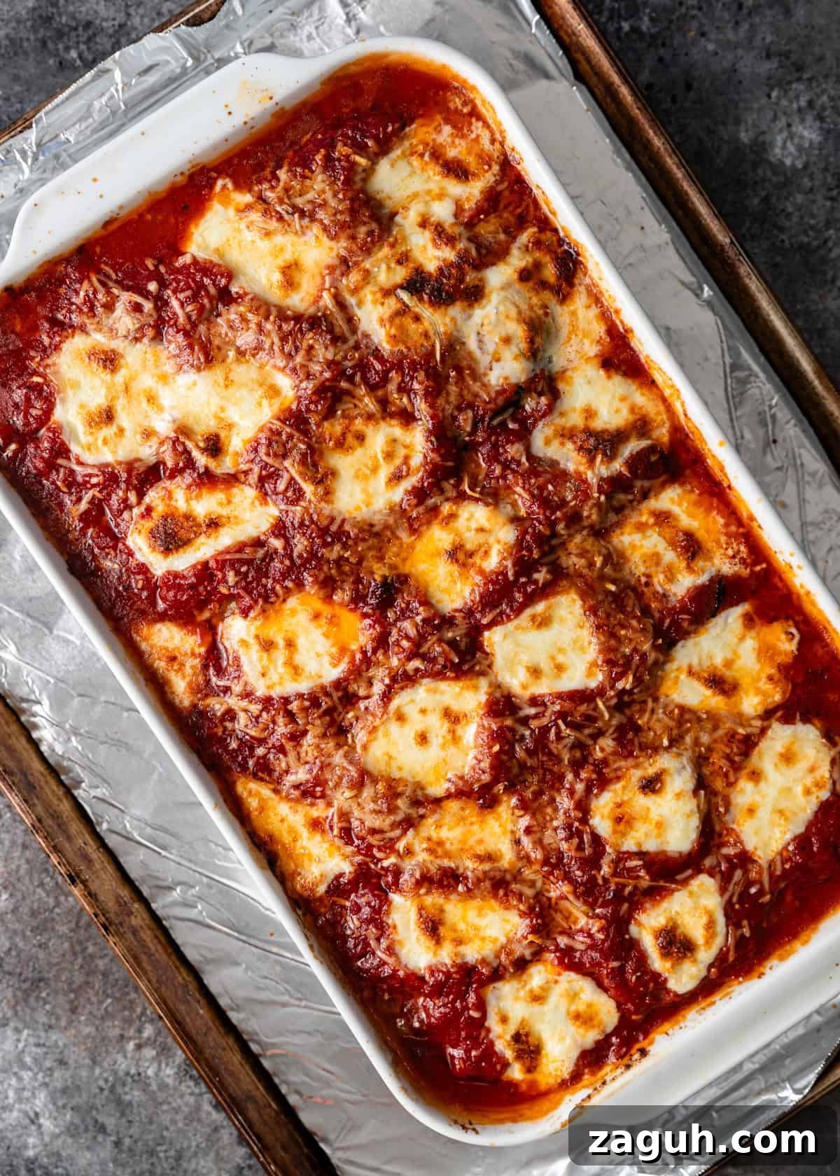 Classic Eggplant Parmigiana Recipe: Authentic Italian Parmigiana di Melanzane 13 overhead process shot: baked eggplant parmigiana on cooking sheet ready to serve