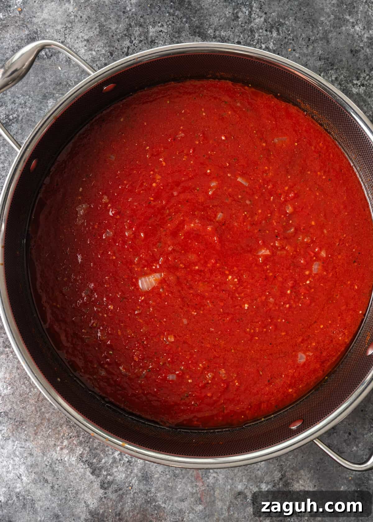 Classic Eggplant Parmigiana Recipe: Authentic Italian Parmigiana di Melanzane 6 overhead process shot: crushed tomatoes and tomato paste added to deep frying pan