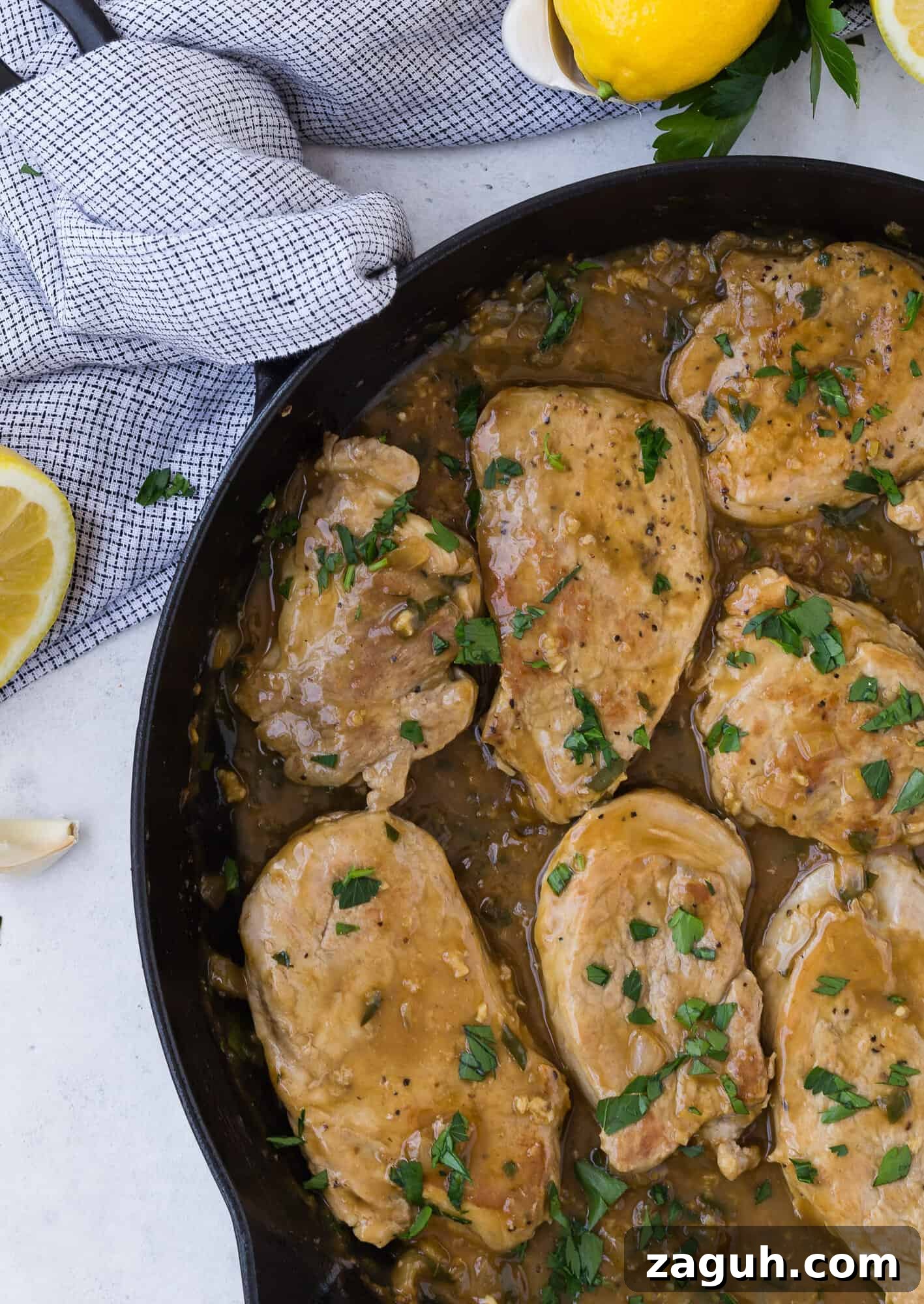 Lemon Garlic Pork Medallions with Creamy Pan Sauce 2 Pork medallions in a black frying pan with sauce.