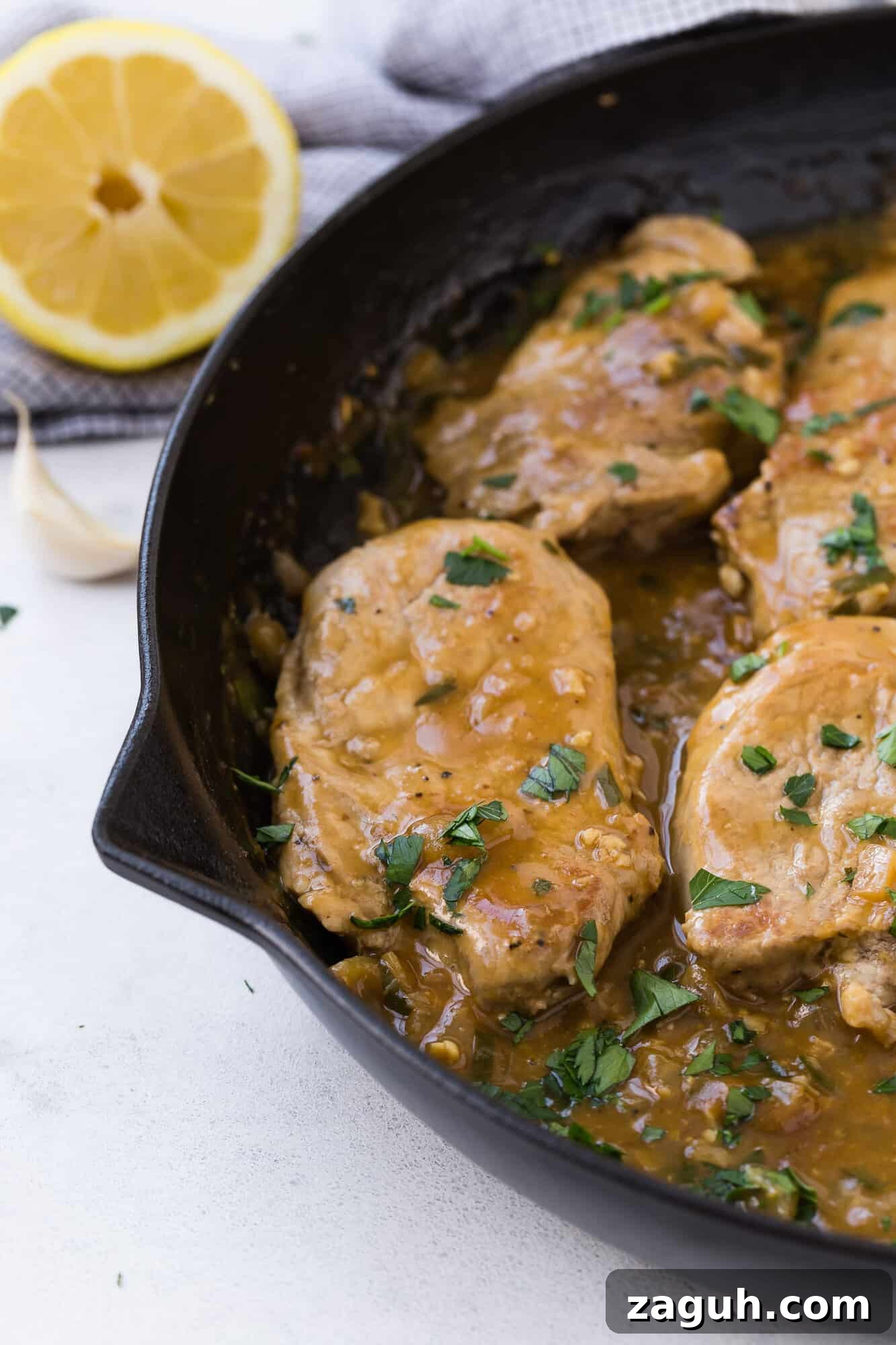 Lemon Garlic Pork Medallions with Creamy Pan Sauce 4 Pork medallions with sauce and parsley.