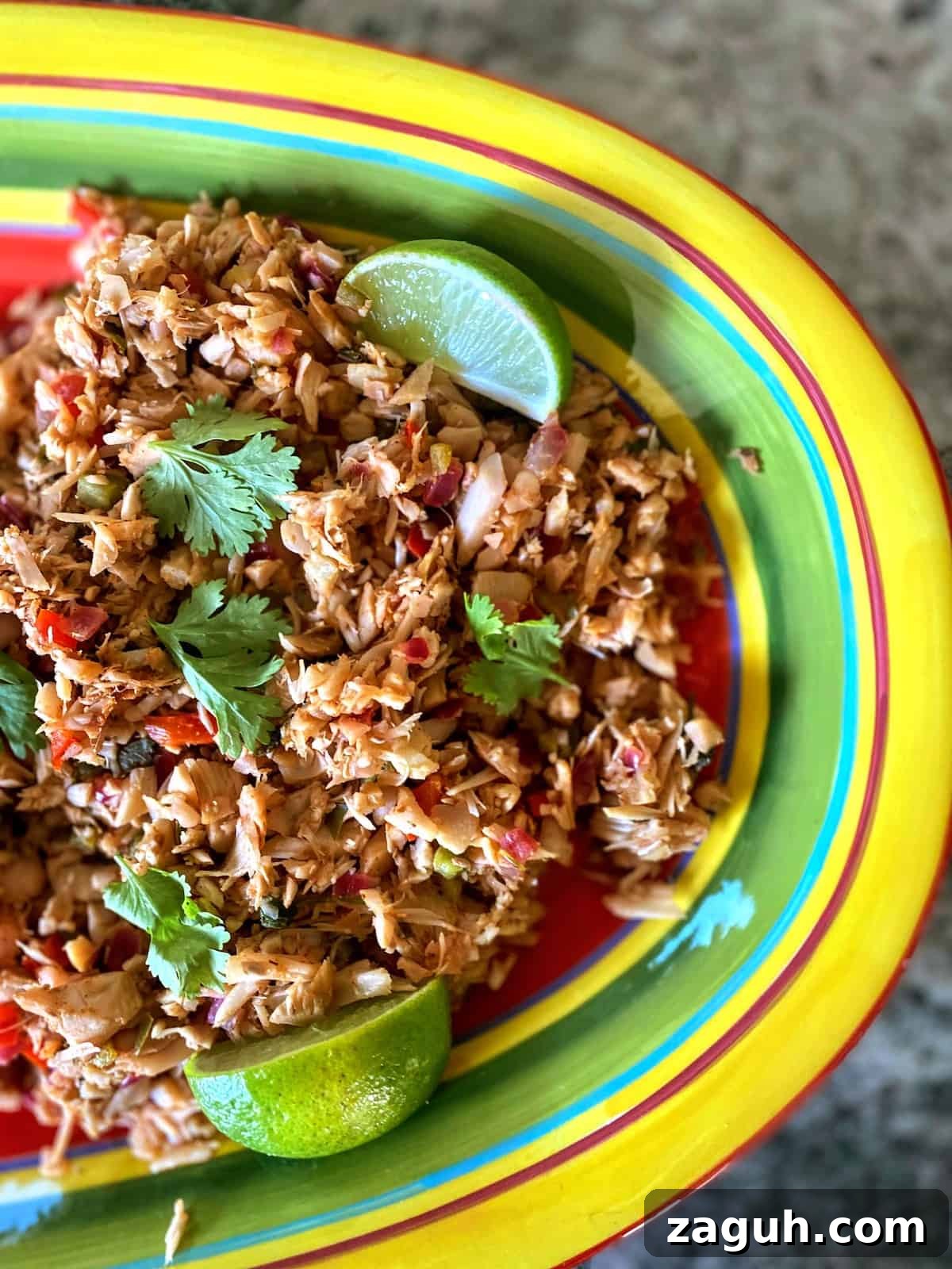 Jackfruit Carnitas: Flavorful Vegan Pulled Pork Tacos 2 Jackfruit carnitas on a platter with lime wedges and cilantro.