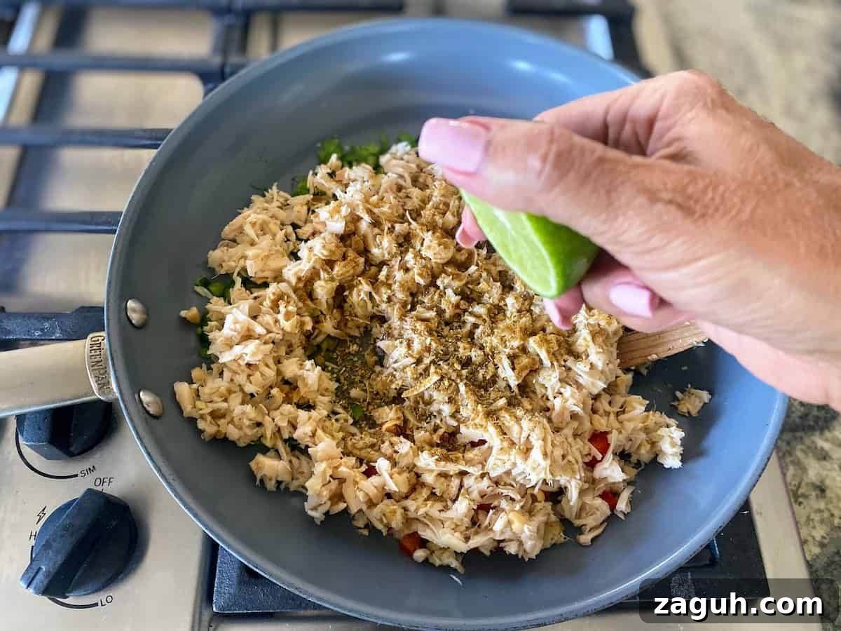 Jackfruit Carnitas: Flavorful Vegan Pulled Pork Tacos 9 Jackfruit cooking in a skillet adding lime juice.