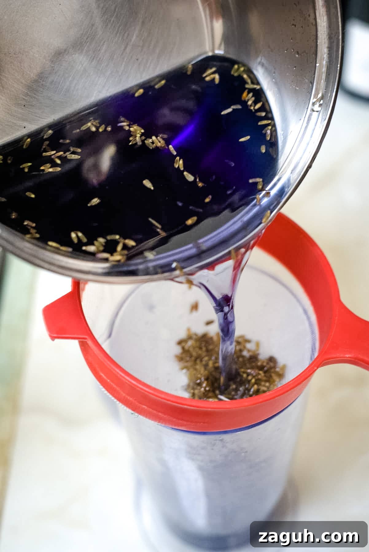 Sugar-Free Lavender Syrup Recipe for Cocktails & Coffee 5 lavender syrup straining into a container