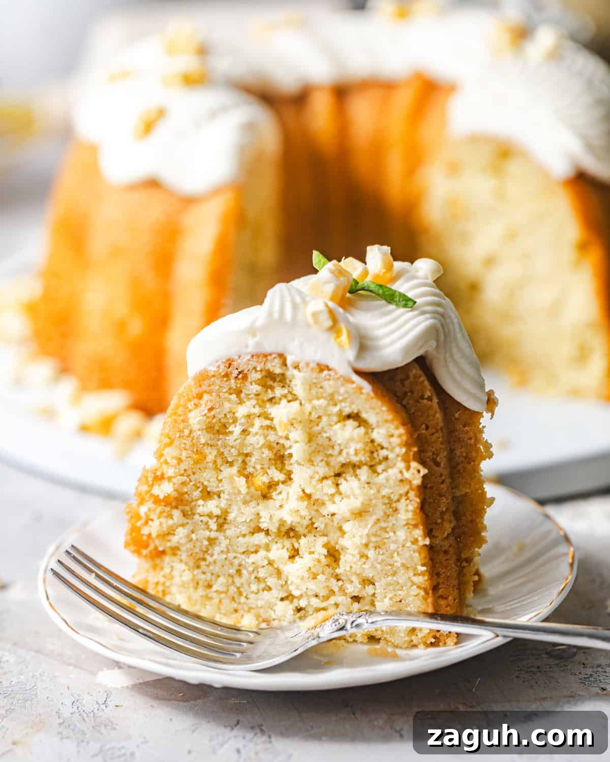 Moist Corn Pound Cake Recipe with Creamy Cornmeal Crumble 11 sliced corn pound cake on a plate with a fork.