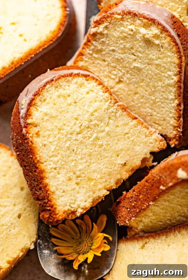 Moist Corn Pound Cake Recipe with Creamy Cornmeal Crumble 13 lemon cream cheese pound cake sliced on a serving tray and topped with cream cheese glaze.