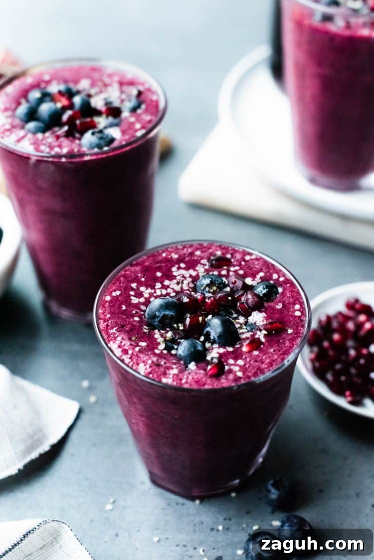 Pomegranate Berry Smoothie Recipe for Fresh Antioxidant Boost 2 Pomegranate Berry Smoothie topped with blueberries, pomegranate arils and hemp seeds.