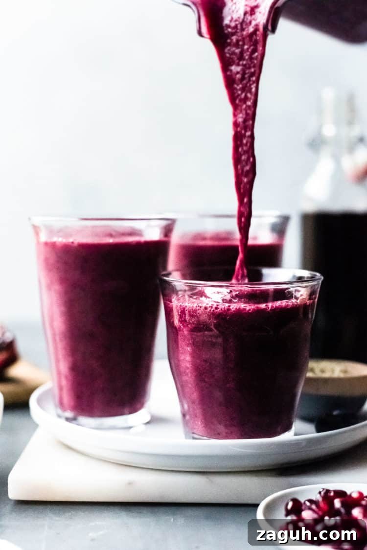 Pomegranate Berry Smoothie Recipe for Fresh Antioxidant Boost 3 Pouring Pomegranate Berry Smoothie into glasses.