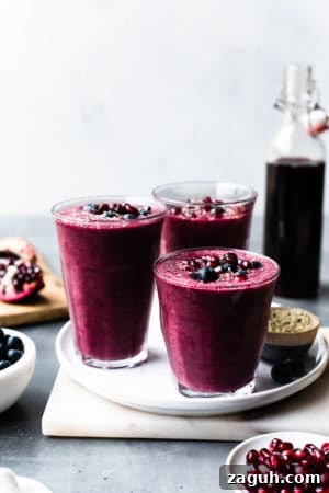 Pomegranate Berry Smoothie Recipe for Fresh Antioxidant Boost 6 Pomegranate Berry Smoothies topped with blueberries and pomegranate arils.