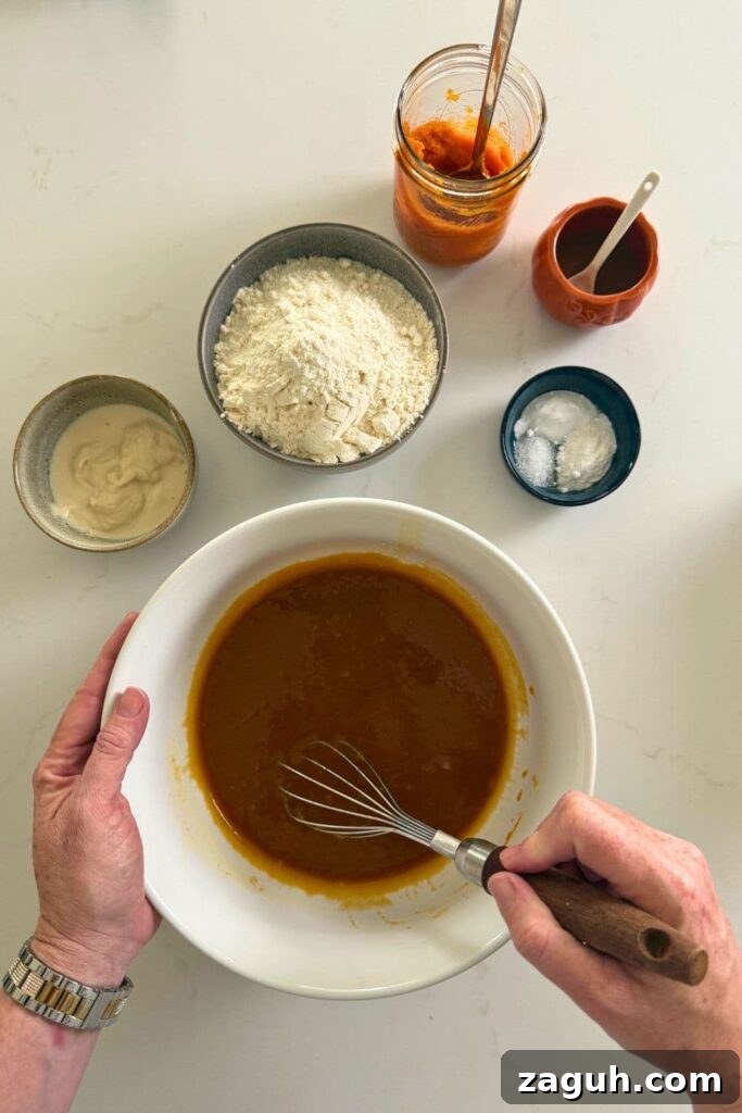 Sourdough Pumpkin Snickerdoodles: Spiced Autumn Cookies Recipe 5 Hand whisking together wet ingredients to make sourdough pumpkin snickerdoodle cookies.