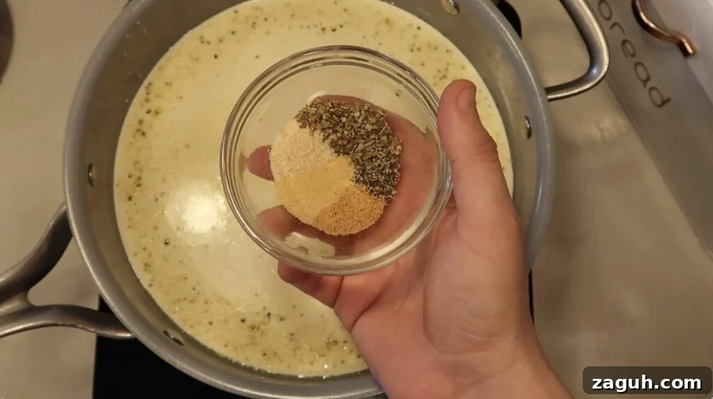 Creamy Garlic Sauce Recipe for Pasta, Chicken, and Veggies 10 Adding seasonings to pan
