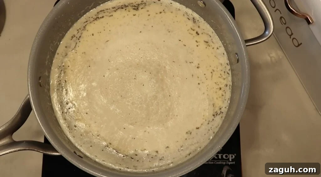 Creamy Garlic Sauce Recipe for Pasta, Chicken, and Veggies 11 Sauce in pan bubbling