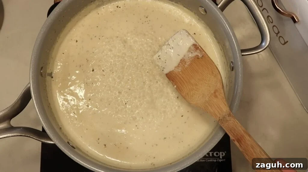 Creamy Garlic Sauce Recipe for Pasta, Chicken, and Veggies 14 Sauce thickened in pan and coating the back of a spoon