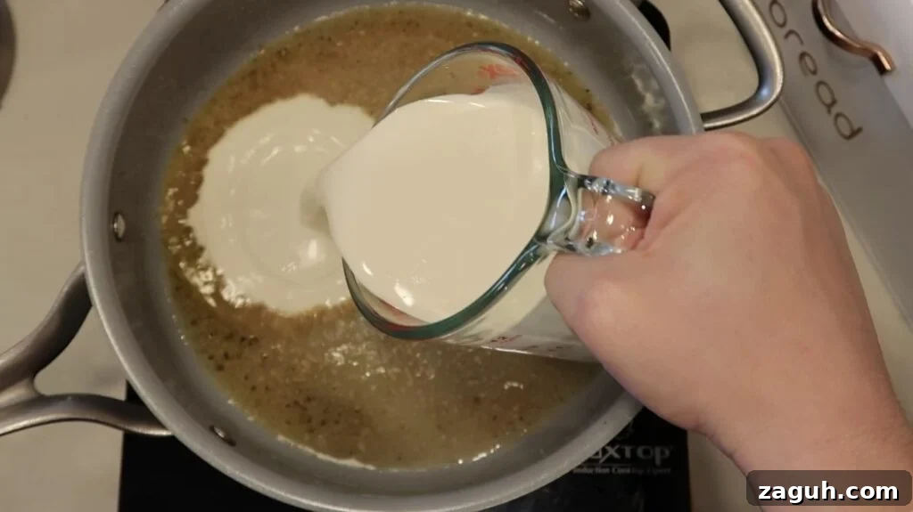 Creamy Garlic Sauce Recipe for Pasta, Chicken, and Veggies 9 Adding heavy cream to pan