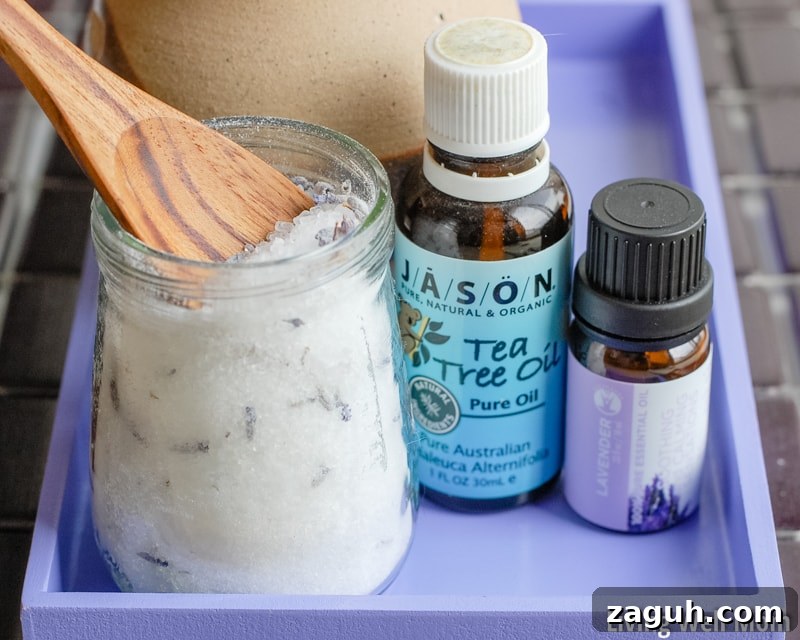 Lavender Epsom Salt Foot Soak Recipe for Relaxation 3 homemade salt foot soak with wooden spoon on purple tray with essential oils