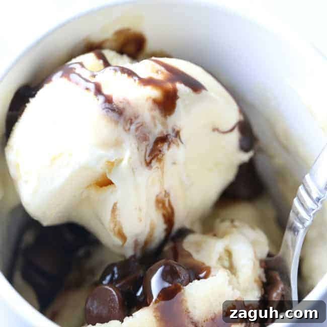 A bowl of dessert in a bowl with Cake and Chocolate syrup.