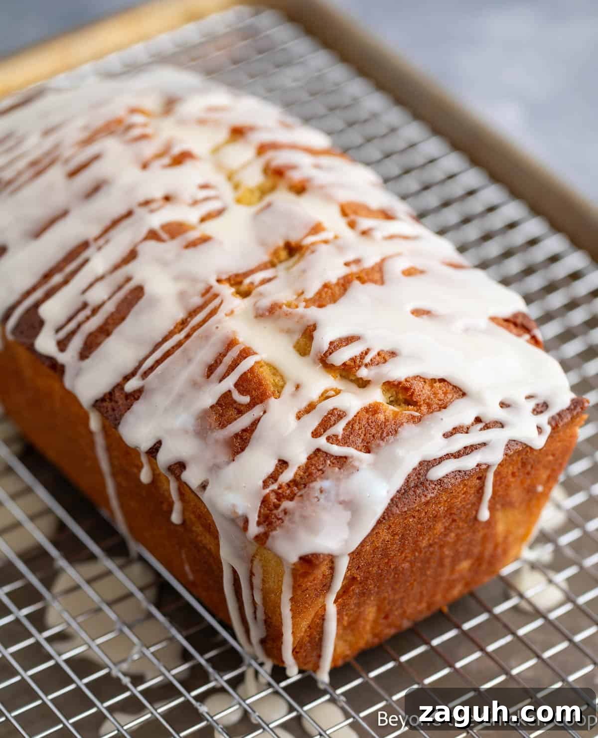 Moist Orange Pound Cake Recipe with Zesty Citrus Glaze 11 A pound cake with icing dripping off the sides.