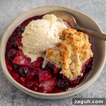 Triple Berry Cobbler topped with a scoop of ice cream.