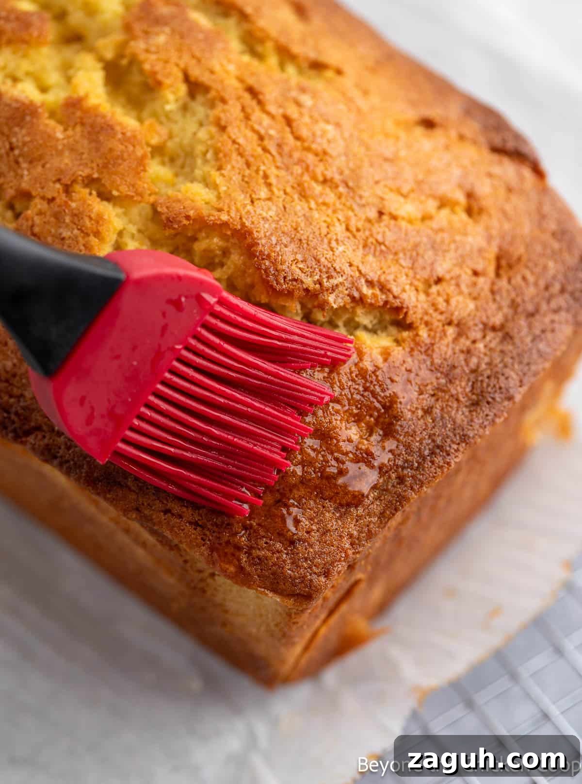 Moist Orange Pound Cake Recipe with Zesty Citrus Glaze 10 Brushing the sides of a loaf with an orange glaze.