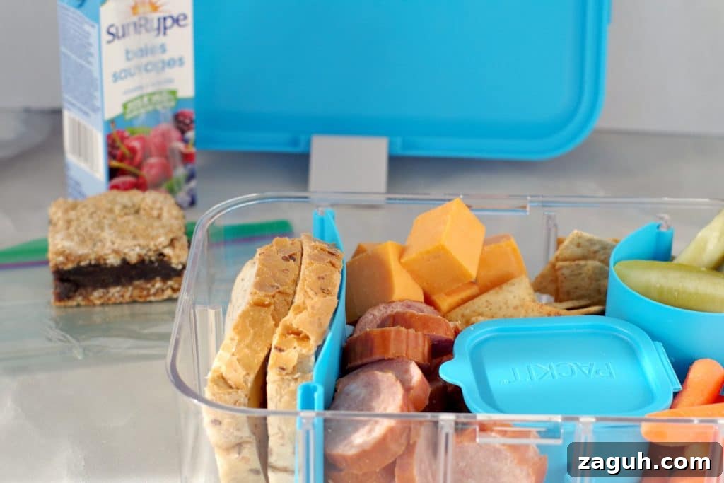 Filled Ukrainian Bento box with juice box, date square and bento box lid in background