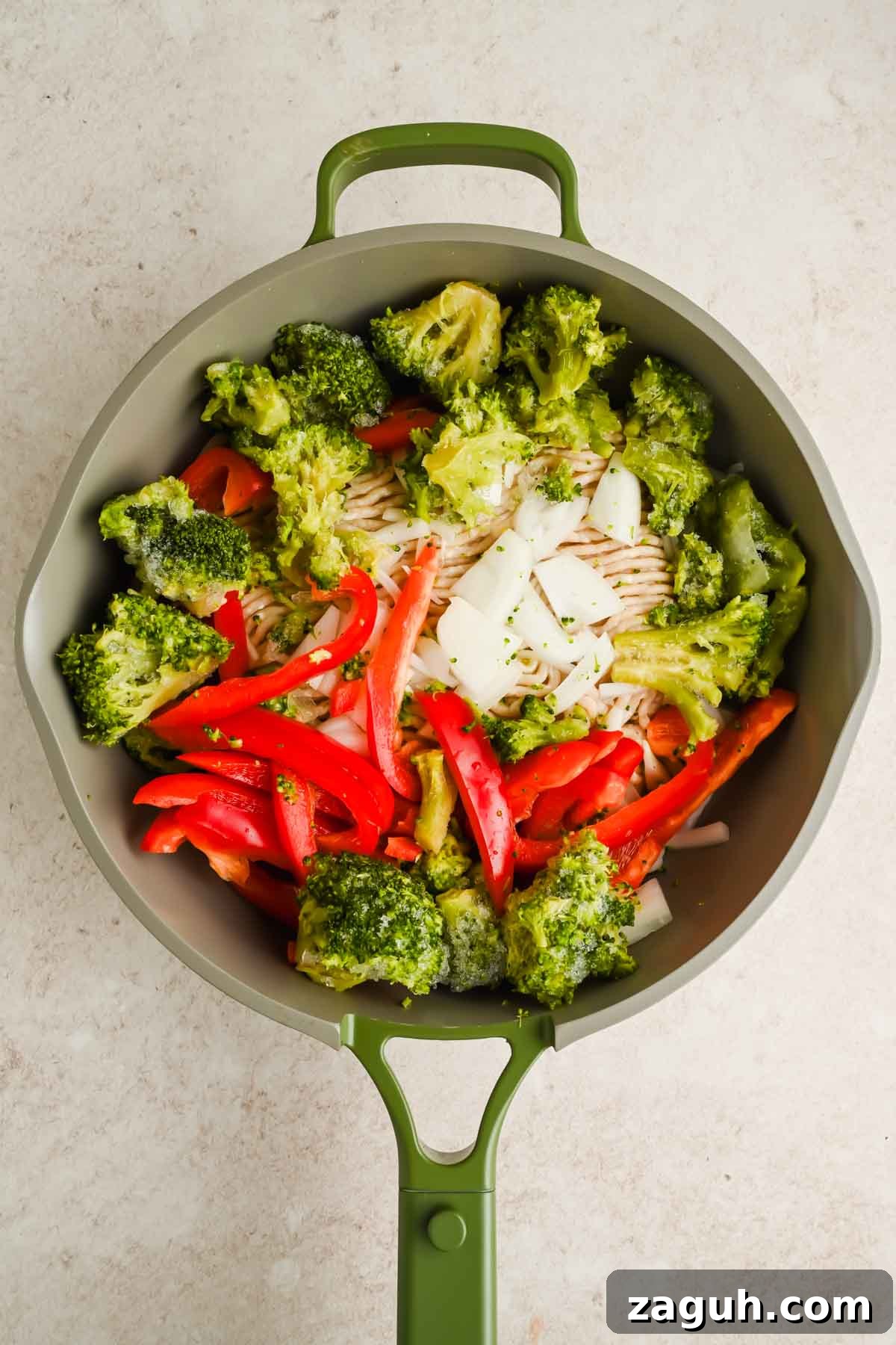 raw veggies and ground chicken in green skillet.