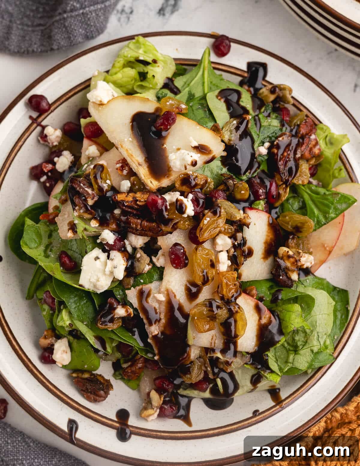 Pomegranate, Pear & Candied Pepita Salad with Citrus Vinaigrette 13 salad with pomegranate arils, feta cheese, sliced apples, and candied pepitas.