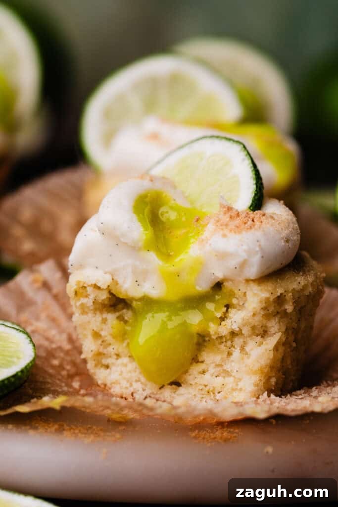 Key Lime Cupcakes with Tangy Lime Curd Filling 11 A close-up of a lime cupcake with a bite missing, showing the lime curd filling inside.
