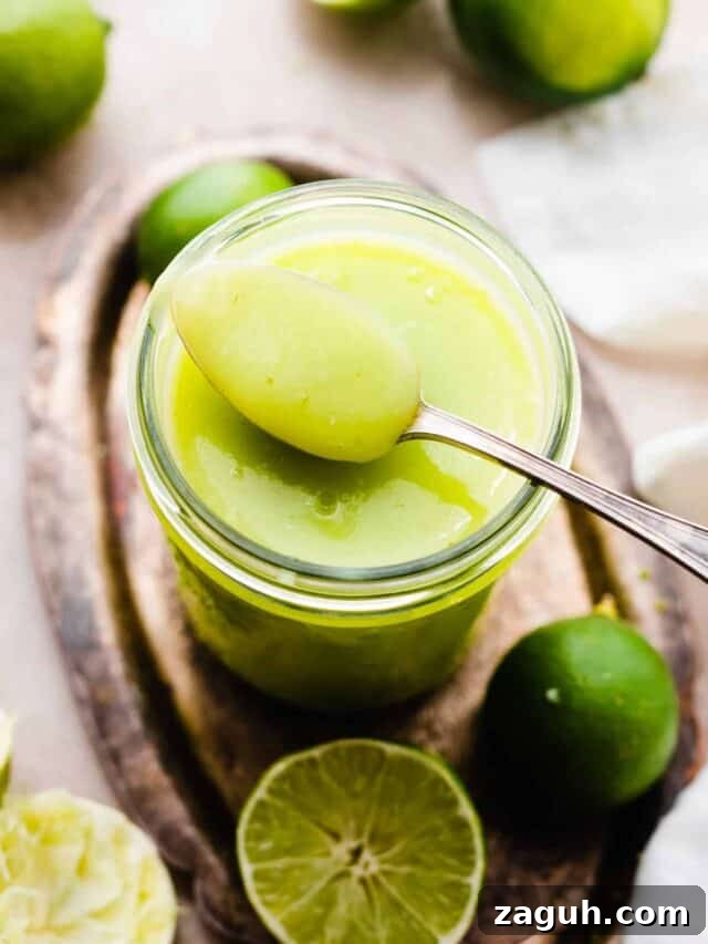 Key Lime Cupcakes with Tangy Lime Curd Filling 4 A jar of lime curd with a spoonful balancing on top.
