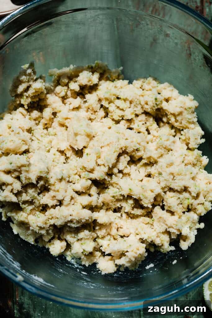 Key Lime Cupcakes with Tangy Lime Curd Filling 6 A bowl of the batter with the wet ingredients partially mixed in. The mixture is thick and clumpy.
