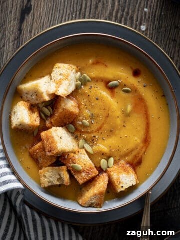 Butternut Squash and Carrot Soup in a bowl with jumbo croutons.