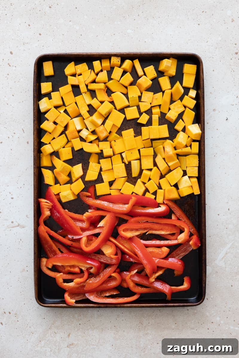 Roasted Butternut Squash and Red Pepper Soup Recipe 4 Butternut squash and red peppers chopped and spread on a baking sheet.