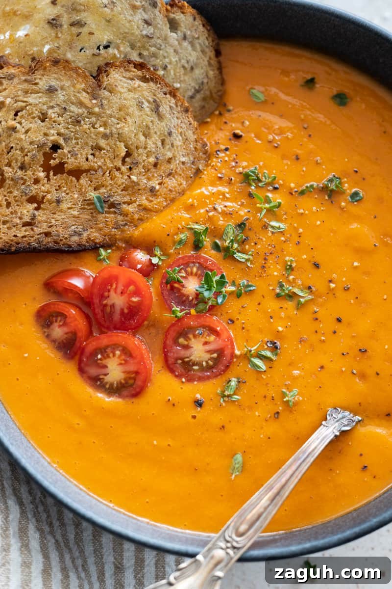 Roasted Butternut Squash and Red Pepper Soup Recipe 7 Closeup of the toppings on the soup: crusty bread, halved cherry tomatoes, fresh thyme, salt and pepper.