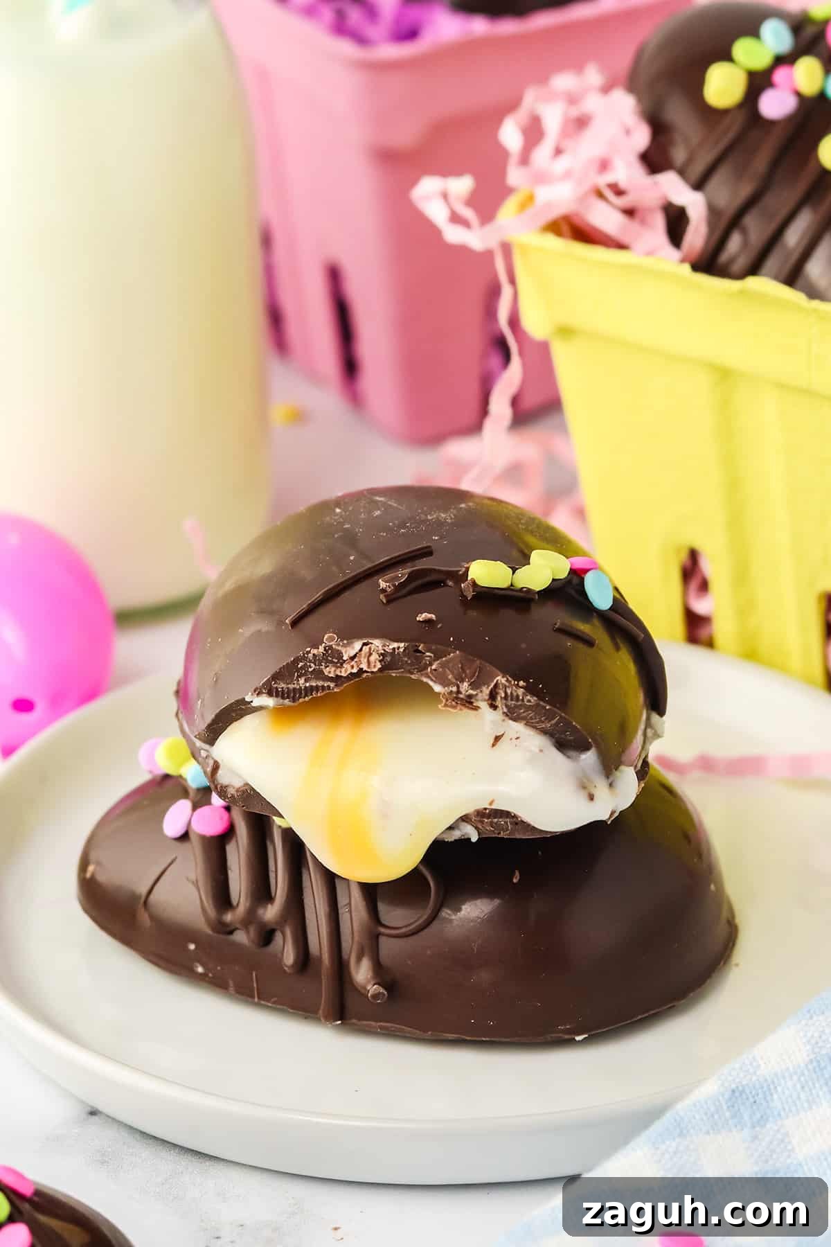 How to Make Copycat Cadbury Creme Egg Candy at Home 11 A chocolate dessert with a glossy exterior and a creamy filling, mimicking Copycat Creme Egg, topped with sprinkles, presented on a plate with an Easter candy-inspired festive background.