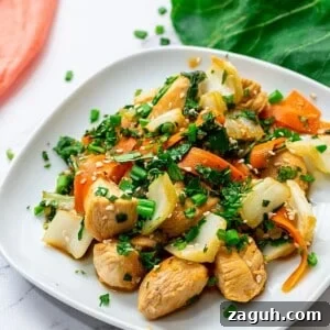 Plate of chicken and bok choy stir fry topped with cilantro.