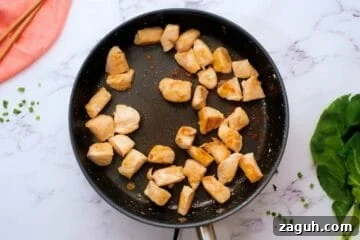 Browned chicken in saute pan to start chicken and bok choy stir fry.