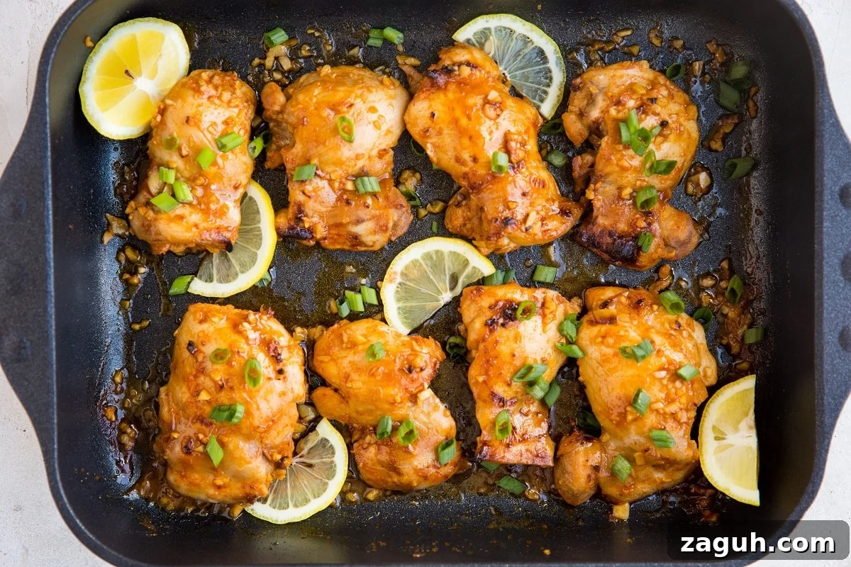 Crispy Lemon Garlic Baked Chicken Thighs with Herb Pan Sauce 3 horizontal top down image of a large casserole dish of chicken thighs