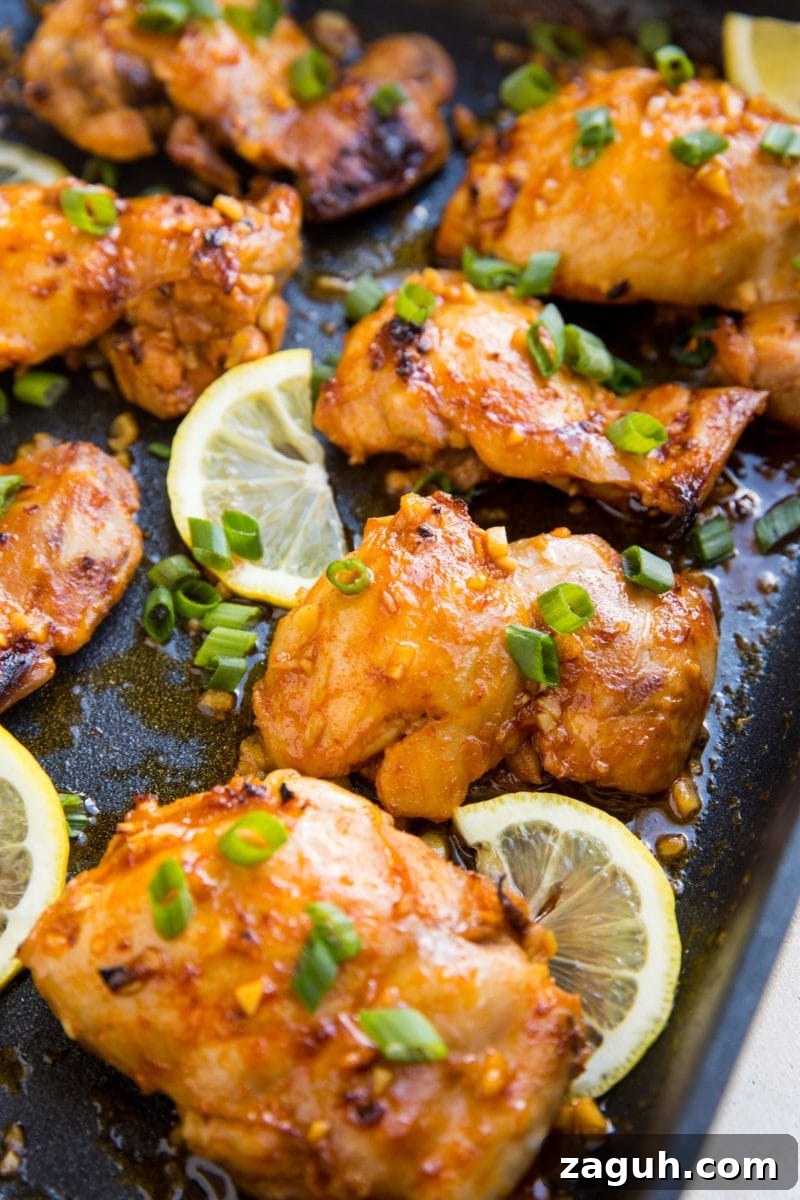 Crispy Lemon Garlic Baked Chicken Thighs with Herb Pan Sauce 4 Large black casserole dish with lemon garlic boneless skinless chicken thighs