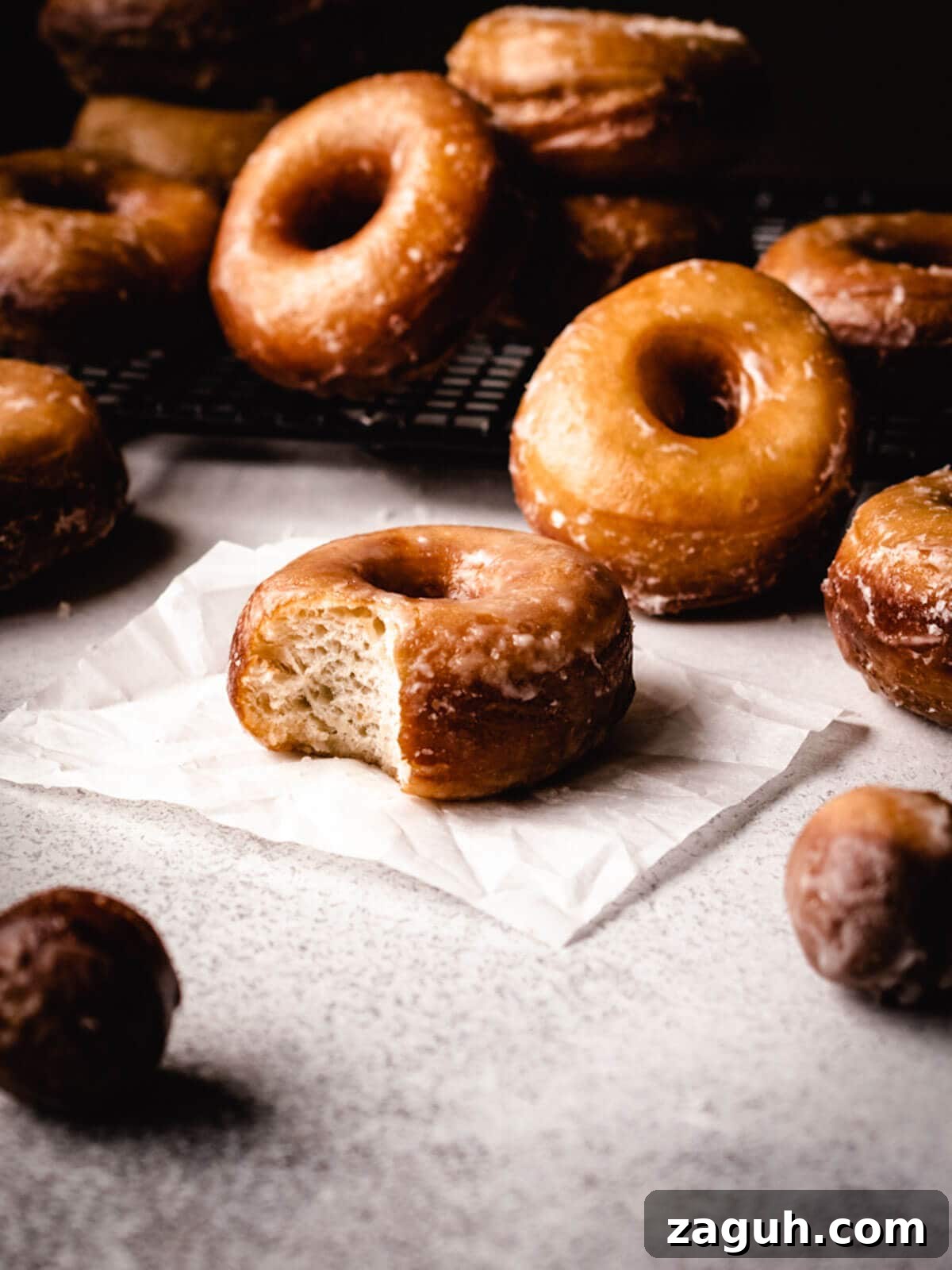 Classic Glazed Donuts: Soft, Shiny, Homemade Recipe 6 Donuts glazed with a bite taken out.