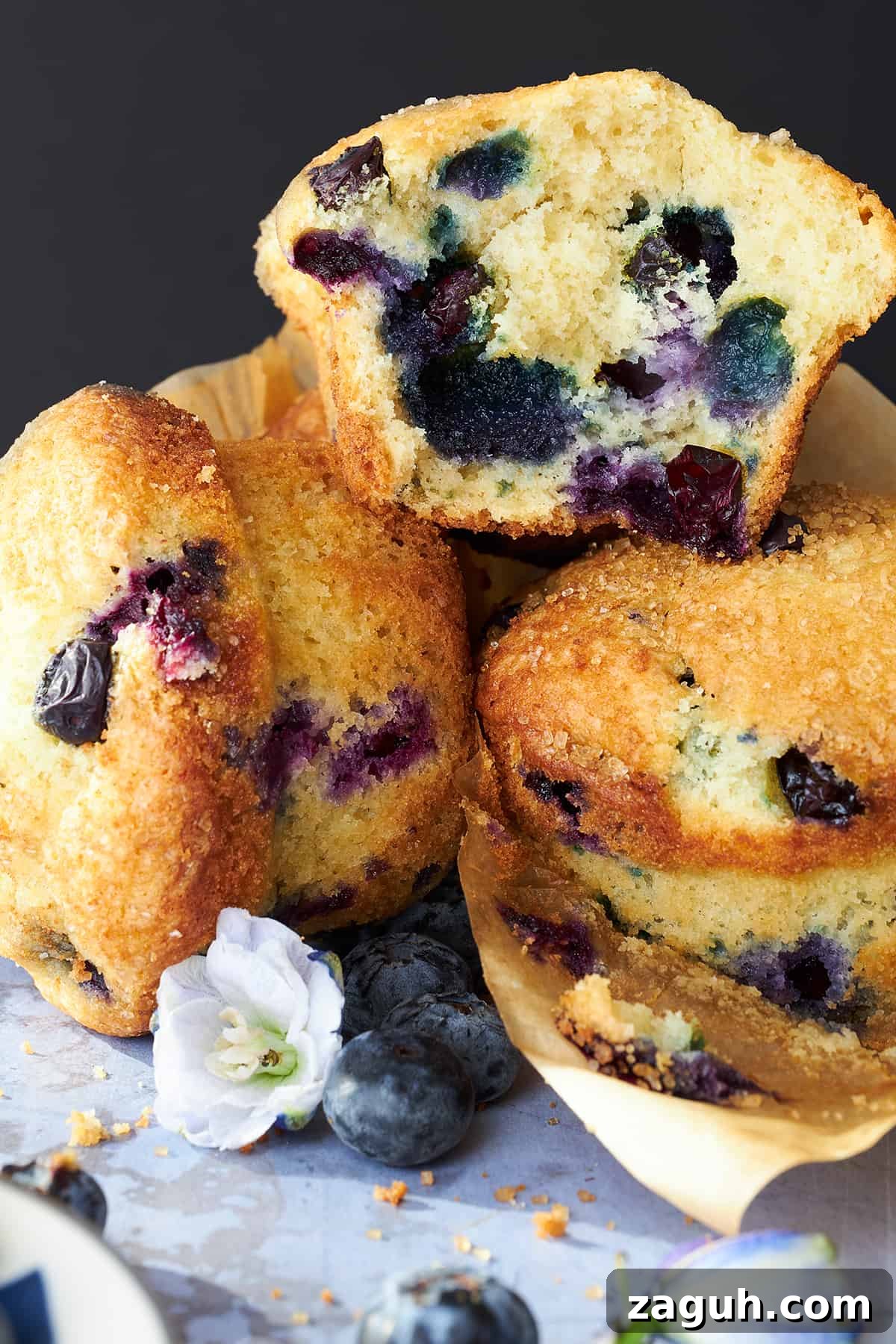 Starbucks-Style Blueberry Muffins Recipe: Make Them at Home 5 A pile of Starbucks blueberry muffins with one split in half exposing the center.